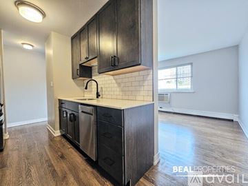 Chicago apartment for rent - A kitchen with black cabinets and a white subway tile backsplash.
