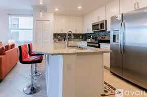 Punta Gorda condo for rent - A kitchen with a bar stool and a refrigerator.