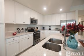 Bradenton condo for rent - A kitchen with white cabinets and a stainless steel sink.
