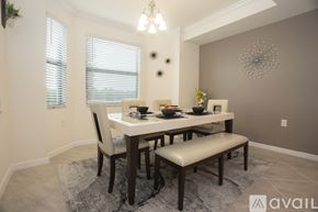 Bradenton condo for rent - A dining room with a table set for two and a bench.