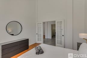 Rowlett house for rent - A bedroom with a round mirror on the wall and a bed with towels on it.