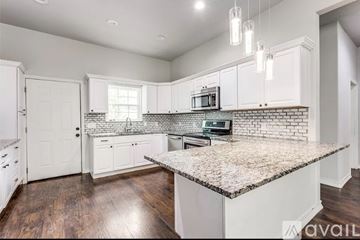 Sherman apartment for rent - A kitchen with white cabinets and a granite countertop.