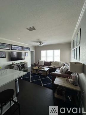 Bradenton condo for rent - A living room with a couch, a chair, and a television.
