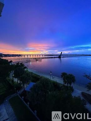 Bradenton condo for rent - A beautiful sunset view of a pier extending into the water with trees in the foreground.
