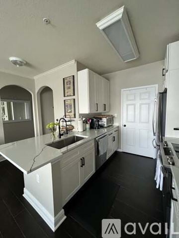 Bradenton condo for rent - A kitchen with white cabinets and a black floor.