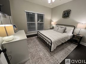Bradenton condo for rent - A bedroom with a large bed, a nightstand with a lamp, and a window with blinds.
