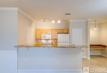 Melbourne apartment for rent - A kitchen with white cabinets and a granite countertop is available.