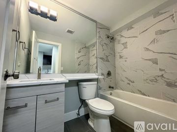 Chicago apartment for rent - A kitchen with brown cabinets and a black fridge.