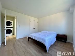 Eureka house for rent - A bedroom with a bed, a bench, and a washing machine in the corner.