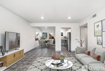San Antonio apartment for rent - A living room with a grey couch, a coffee table, and a television on a wooden stand.
