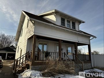 Wausau house for rent - A kitchen with white cabinets and a red chair.