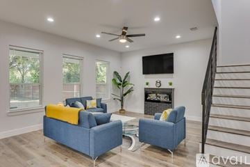 Dallas house for rent - A living room with a blue couch and a television mounted on the wall.