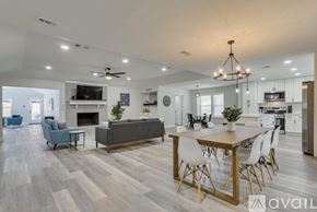 Garland house for rent - A modern living room with a grey couch, a wooden dining table, and a fireplace.