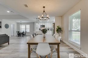 Garland house for rent - A modern dining room with a wooden table and white chairs.