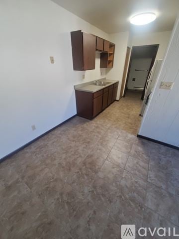 La Crosse apartment for rent - A kitchen area with brown cabinets and a tiled floor.