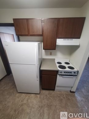 La Crosse apartment for rent - A small kitchen with a white refrigerator and a white stove top oven.