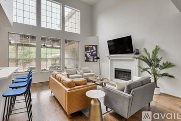 Mesquite house for rent - A living room with a grey couch, a white fireplace, and a television on the wall.