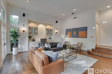 Dallas house for rent - A modern living room with a brown leather couch and a glass coffee table.