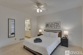Dallas house for rent - A bedroom with a large bed, a ceiling fan, and a mirror on the wall.