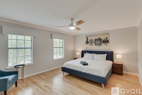 Plano house for rent - A bedroom with a bed, a chair, and a ceiling fan.