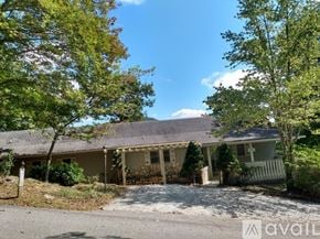 Dillard house for rent - A house with a gravel driveway and trees in the background.