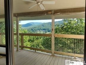 Dillard house for rent - A mountain range is visible through a window with a wooden railing.