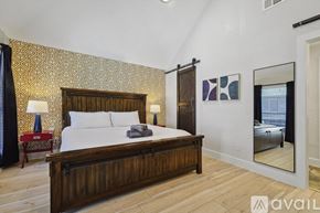 Plano house for rent - A bedroom with a large bed and a mirror on the wall.