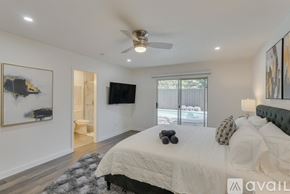 Dallas house for rent - A bedroom with a large bed and a flat screen TV mounted on the wall.