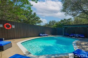 Dallas house for rent - A pool with a blue tiled edge and a red life preserver on the fence.