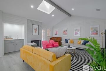 Richardson house for rent - A living room with a yellow sofa and a striped rug.