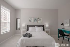 Grand Prairie house for rent - A bedroom with a large bed, a desk with a chair, and two nightstands with lamps.