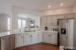 Grand Prairie house for rent - A kitchen with white cabinets and a stainless steel refrigerator.