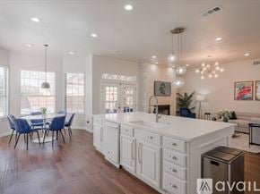 Mckinney house for rent - A modern kitchen with white cabinets and a large island.