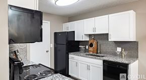 Blacklick apartment for rent - A kitchen with black appliances and white cabinets.