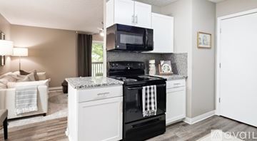Blacklick apartment for rent - A modern kitchen with a black oven and white cabinets.