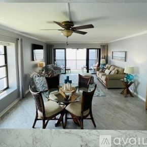 North Fort Myers condo for rent - A dining room with a table set for six and a couch in the background.
