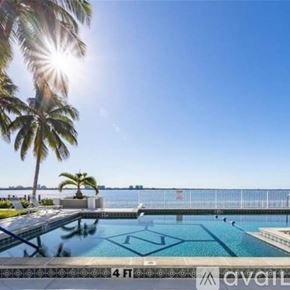 North Fort Myers condo for rent - A pool surrounded by palm trees with the sun shining brightly.