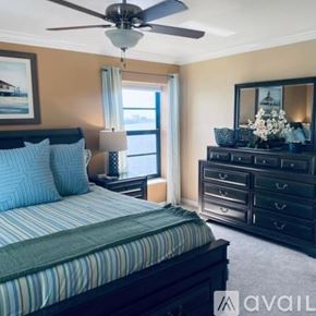 North Fort Myers condo for rent - A bedroom with a bed, dresser, and a ceiling fan.