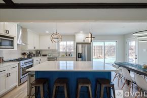 Richardson house for rent - A kitchen with white cabinets and a blue backsplash.