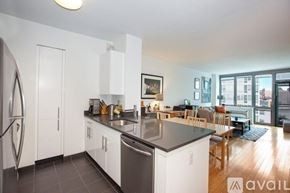 Manhattan apartment for rent - A kitchen with white cabinets and a black countertop.