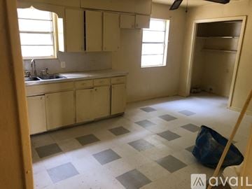 North Little Rock house for rent - A kitchen with white cabinets and a checkered floor.