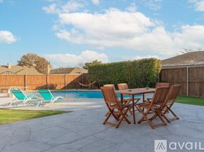 Garland house for rent - A backyard with a pool, chairs, and a table.