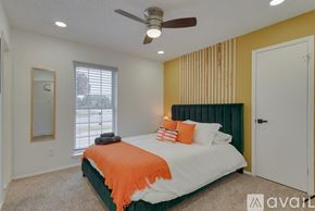 North Richland Hills house for rent - A bedroom with a bed, pillows, and a ceiling fan.