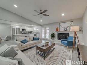 Garland house for rent - A living room with a white couch, a blue armchair, a coffee table, and a fireplace.