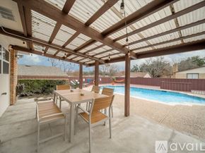 Garland house for rent - A patio with a table and chairs overlooking a pool.
