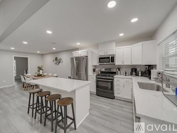 Garland house for rent - A modern kitchen with white cabinets and a large island.