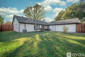 Plano house for rent - A house with a white exterior and a grey roof is surrounded by a green lawn.