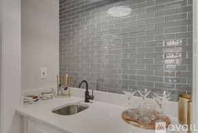 Plano house for rent - A kitchen with a sink and a tiled backsplash.