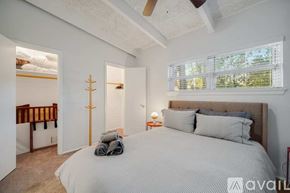 Irving house for rent - A bedroom with a large bed and a window with blinds.