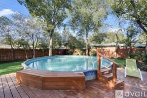 Irving house for rent - A wooden deck with a round blue pool in the middle surrounded by trees.